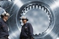 Two engineers and cogwheels axle Royalty Free Stock Photo