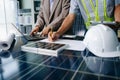 Two engineers collaborate on solar and wind energy, driving clean innovation and sustainability. A vision of teamwork