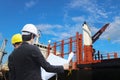 Workers hand holding blue print during planning in shipyard