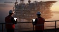 Two Engineers Inspecting Offshore Oil Rig During Sunset Examining Operations Using Tablet Technology Reflecting Energy Industry Royalty Free Stock Photo