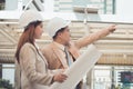 Two engineers meeting at construction site. Coworkers discussing.