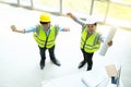 Two engineers man standing near table and raise his hand and feeling happy on successful project