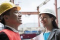 Two engineers smiling in protective workwear outside in a shipping yard Royalty Free Stock Photo