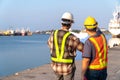 Two engineers stood wearing a safety helmet. Standing at the pier And holding the blueprint And consult the plan In the constructi