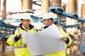 Two engineers are talking in front of electrical transmission lines, working on renewable energy development. Engineers Royalty Free Stock Photo