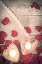 Two enlightened candles in heart-shaped candleholders with rose