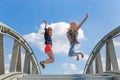 Two enthusiastic girls jumping on bridge Royalty Free Stock Photo