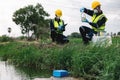 Two Environmental Engineers Inspect Water Quality and Take Water Samples Notes in The Field Near Farmland, Natural Water Sources Royalty Free Stock Photo