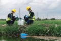 Two Environmental Engineers Inspect Water Quality and Take Water Samples Notes in The Field Near Farmland, Natural Water Sources Royalty Free Stock Photo