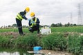 Two Environmental Engineers Inspect Water Quality and Take Water Samples Notes in The Field Near Farmland, Natural Water Sources Royalty Free Stock Photo