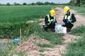 Two Environmental Engineers Inspect Water Quality and Take Water Samples Notes in The Field Near Farmland, Natural Water Sources Royalty Free Stock Photo