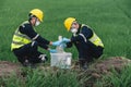 Two Environmental Engineers Take Water Samples at Natural Water Sources Near Farmland Maybe Contaminated by Toxic Waste or Royalty Free Stock Photo