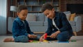 Two ethnic little boys African American multiracial kids schoolboys pupils children play game sitting on carpet in Royalty Free Stock Photo