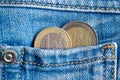 Two Euro coins with a denomination of 1 and 2 euro in the pocket of worn old blue denim jeans Royalty Free Stock Photo