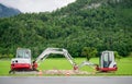 Two excavators working together on roadside construction in green alpine landscape in Austria Royalty Free Stock Photo