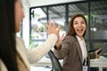 Two excited businesswomen are screaming with joy and giving high fives to cheer up Royalty Free Stock Photo