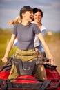 Two excited girls driving quad together Active vacation concept