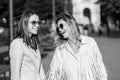 Two excited happy women walking together on the street. High Fashion amazed model woman posing in city street. Happy Royalty Free Stock Photo