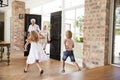 Two excited kids rush to meet their visiting grandparents