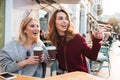 Two excited smiling girls holding coffee cups Royalty Free Stock Photo