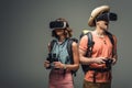 Two excited tourists with binoculars and digital camera using virtual reality headsets