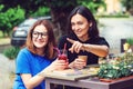 Two excited young girls talking in summer cafe outdoors. Happy friends. Young women drinking juice and enjoying in conversation. Royalty Free Stock Photo