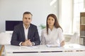 Serious businesspeople sitting at office desk and looking at camera during work meeting or interview Royalty Free Stock Photo