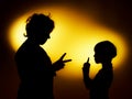 Two expressive boy's silhouettes showing emotions using gesticu Royalty Free Stock Photo