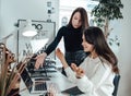 Two expressive girls talks about their work in office room Royalty Free Stock Photo