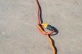Two extension cords plugged into each other with a knot on a cement background Royalty Free Stock Photo