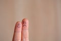 Two faces on fingers, couple of happy and unhappy mood, concept of negative or positive