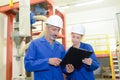 Two factory workers looking at clipboard Royalty Free Stock Photo