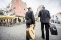 Two fado guitarists walking on Alfama street in Lisbon, Portugal