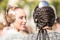 Two falleras talking. Detail of the hairstyle typical in this valencian celebration. Hair bun seen from behind