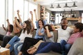 Two Families Watching Sports On Television And Cheering Royalty Free Stock Photo