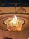 Two fancy drinks in front of a propane gas fire pit at an outdoor bar Royalty Free Stock Photo