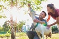 Two farmers, husband and wife tending to their goat on their farm