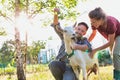 Two farmers, husband and wife tending to their goat on their farm