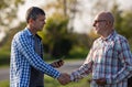 Two farmers shaking hands in field Royalty Free Stock Photo