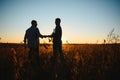 Two farmers shaking hands in soybean field. Royalty Free Stock Photo