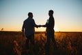 Two farmers shaking hands in soybean field. Royalty Free Stock Photo