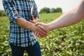 Two farmers shaking hands in soybean field in early summer Royalty Free Stock Photo