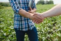 Two farmers shaking hands in soybean field in early summer Royalty Free Stock Photo