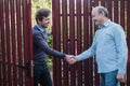 Two farmers shaking hands and takling to each other