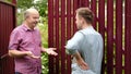 two farmers takling to each other on sunny day. They discuss important news