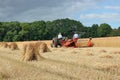 Two farmers working a reaper-binder in a field.