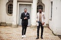 Two fashion black men. Fashionable portrait of african american male models. Wear suit, coat and hat Royalty Free Stock Photo