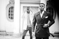 Two fashion black men. Fashionable portrait of african american male models. Wear suit, coat and hat Royalty Free Stock Photo