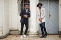 Two fashion black men. Fashionable portrait of african american male models. Wear suit, coat and hat Royalty Free Stock Photo