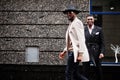 Two fashion black men walking on street. Fashionable portrait of african american male models. Wear suit, coat and hat Royalty Free Stock Photo